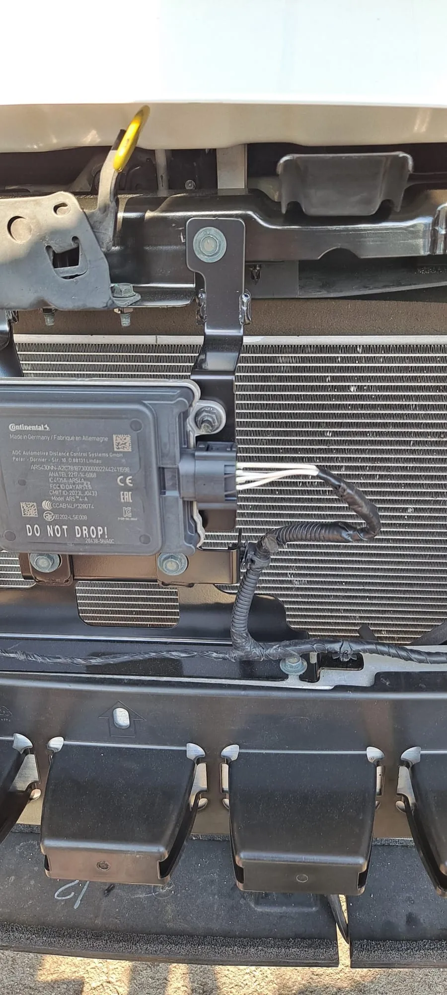 The replacement connector fitted to the module behind the front bumper, with the harness back in its loom and clipped down