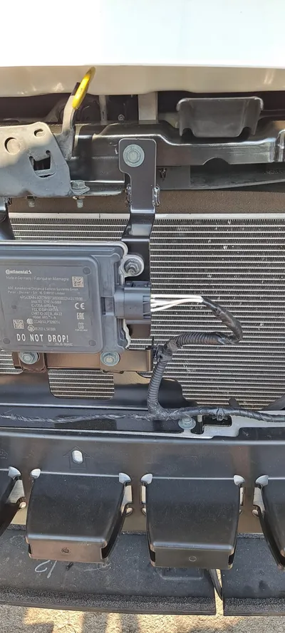 The replacement connector fitted to the module behind the front bumper, with the harness back in its loom and clipped down