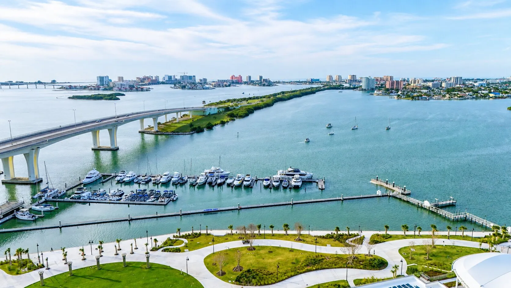 Aerial view of Clearwater Harbor, with the Memorial Causeway bridge crossing toward Clearwater Beach and boats moored at the downtown marina